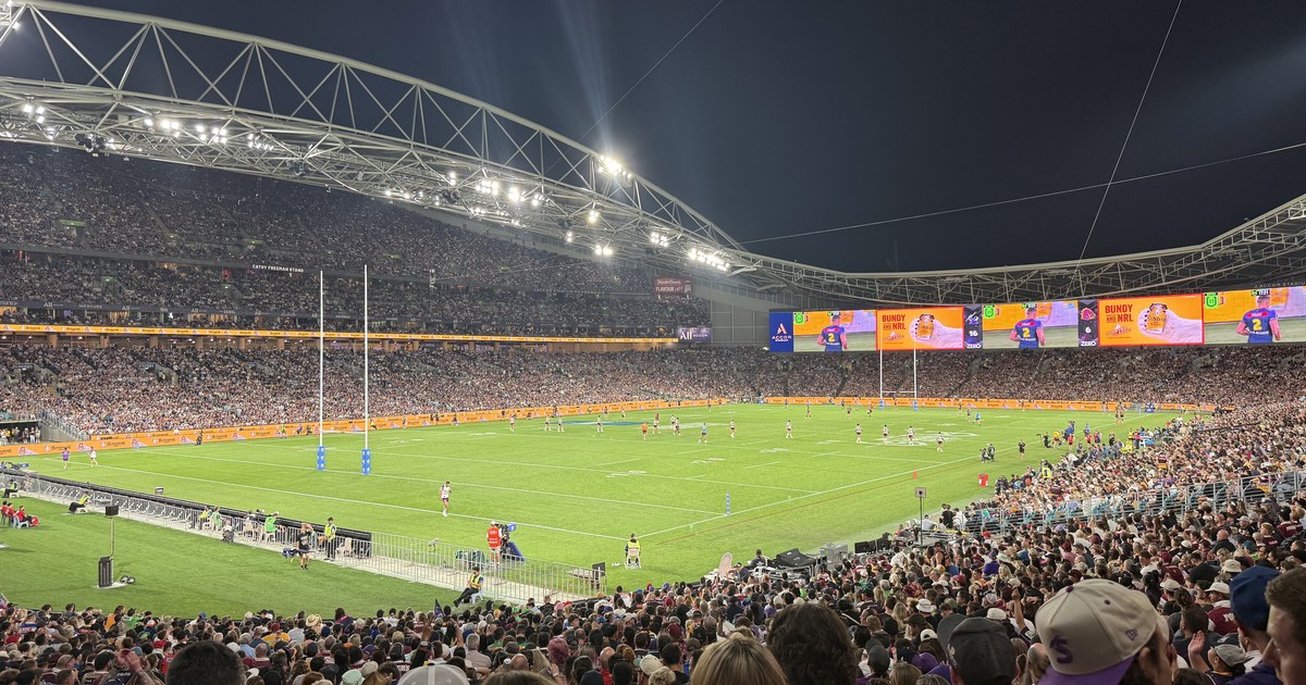 Accor Stadium packed for an NRL grand final at night, play in progress under floodlights