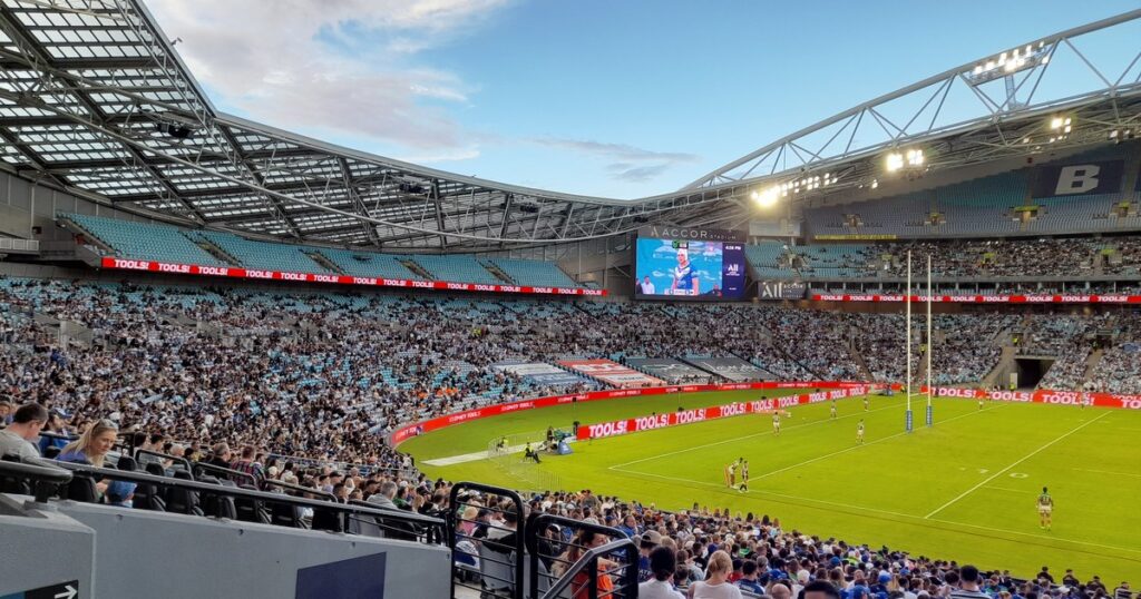 Accor Stadium in Sydney filled for an NRL match, with the big screen showing the Accor Stadium name