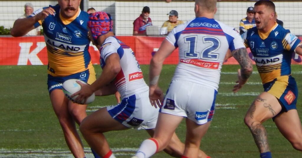 Newcastle Knights player breaking a tackle against the Parramatta Eels in an NRL finals match