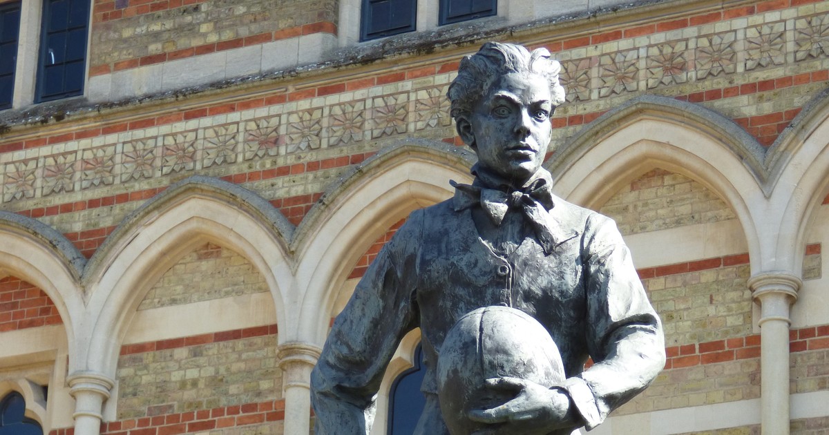 Statue of William Webb Ellis holding a rugby ball at Rugby School