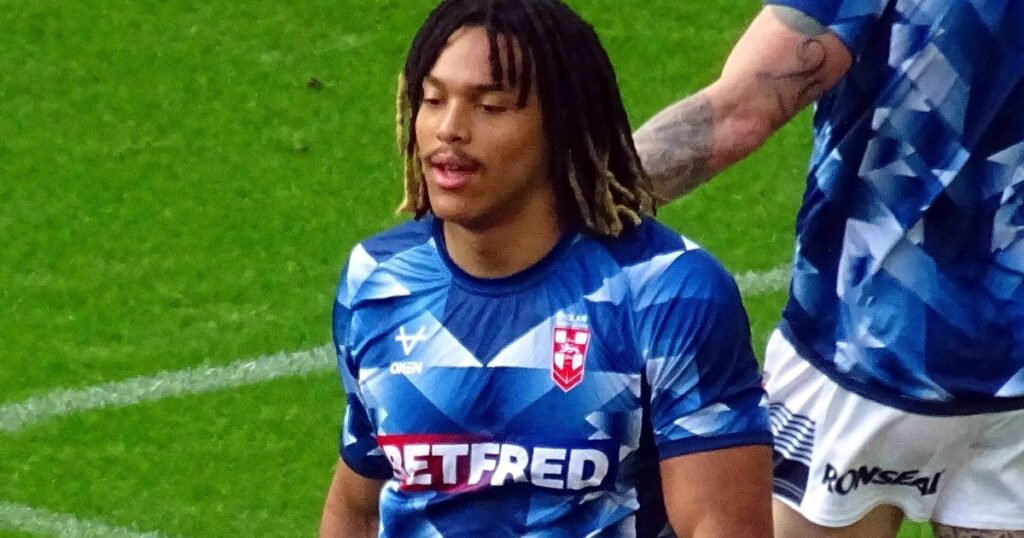 Dom Young in a blue England rugby league training top on the pitch