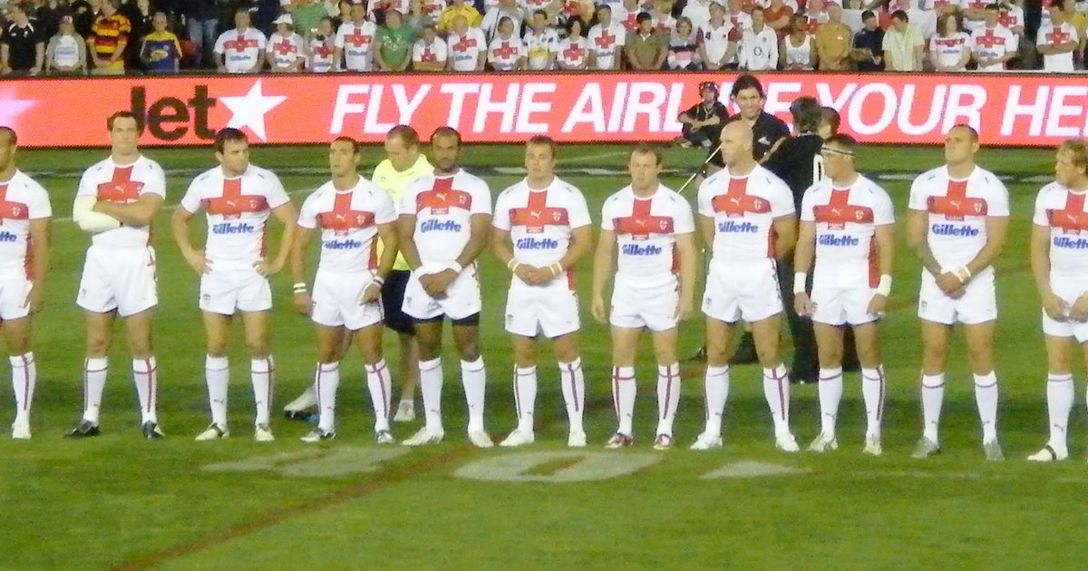 The England rugby league team in white jerseys lined up on the pitch before a World Cup match