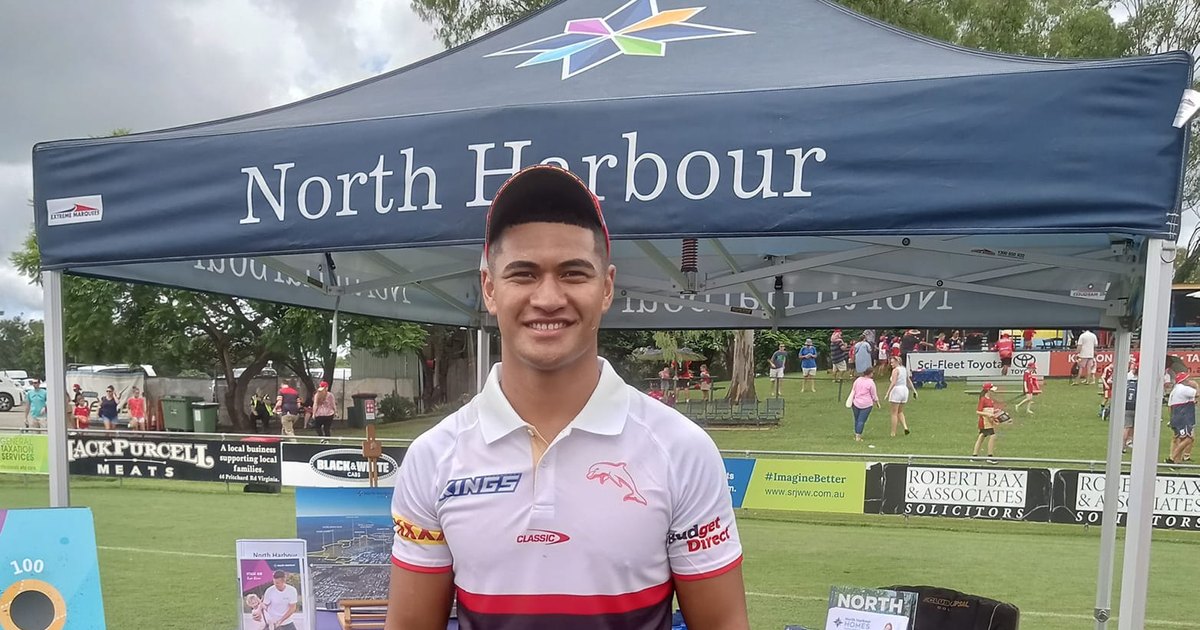 Isaiya Katoa in a white Dolphins shirt standing at a community rugby league event