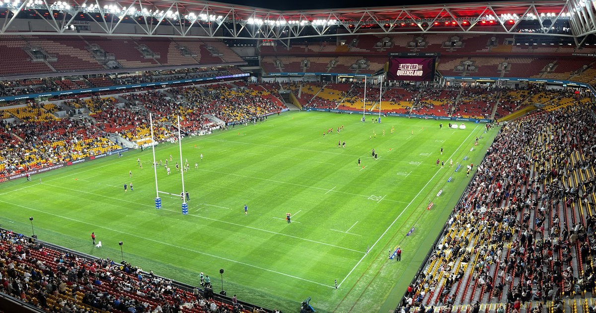 Suncorp Stadium in Brisbane under lights during a match, seen from the upper stand