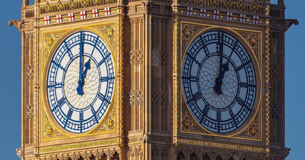 Two clock faces of Big Ben on the Elizabeth Tower in London against a blue sky