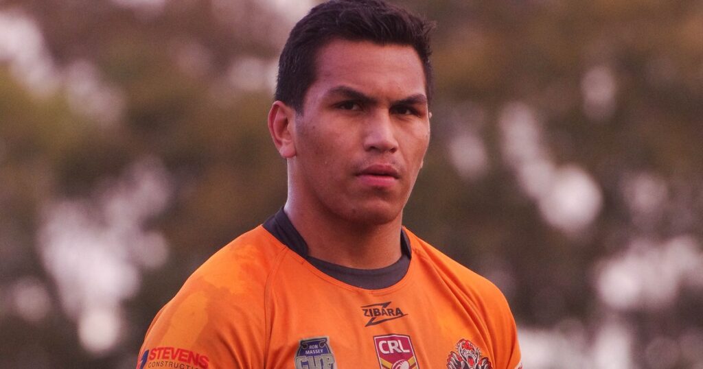 Jacob Saifiti in an orange rugby league jersey on the field