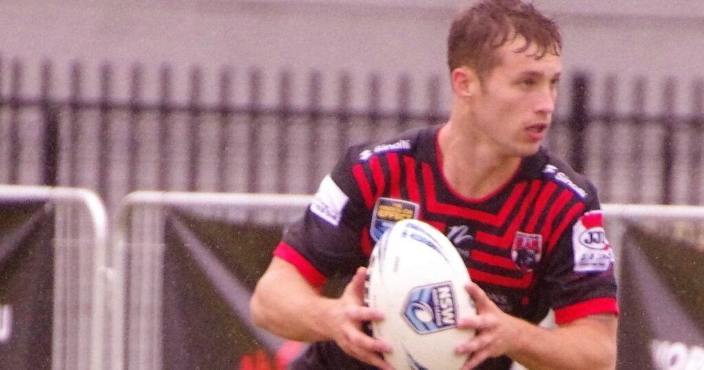 Sam Walker running with the ball in a red and black jersey