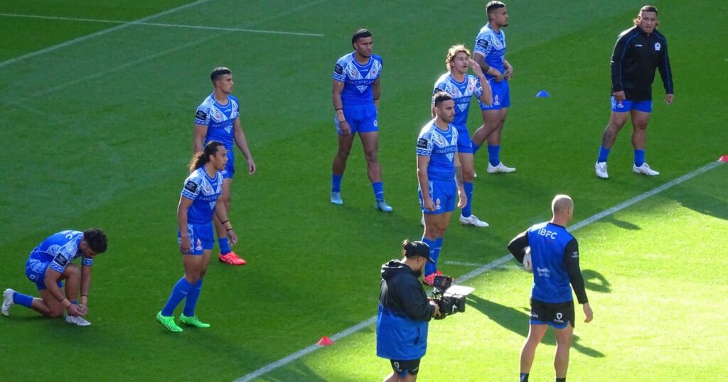 Samoa rugby league players in blue warming up on the pitch before a World Cup match