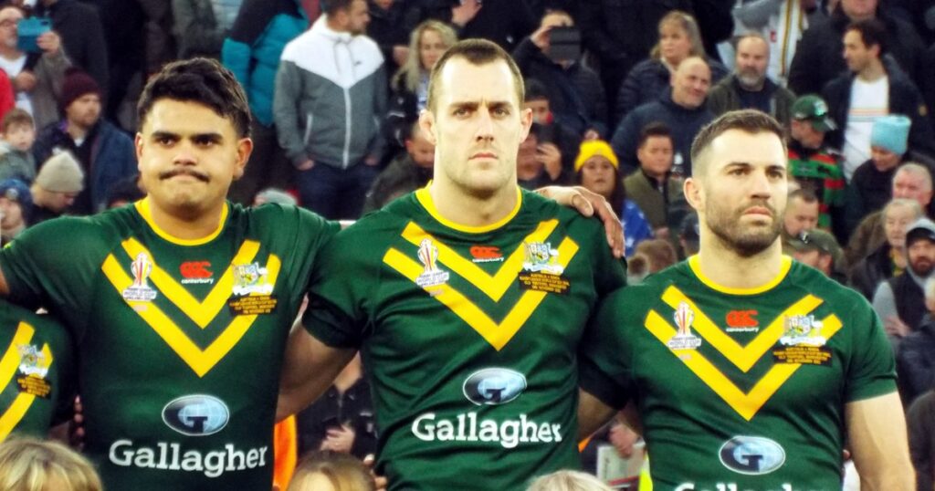 Three Australia players standing arm in arm during the anthem before a World Cup final
