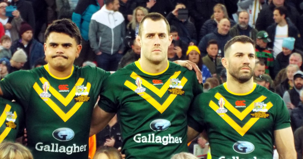 Three Australia players standing arm in arm during the anthem before a World Cup final